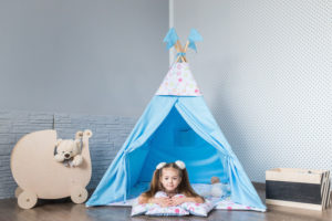 Child, preschooler kids, playing at home indoors with a teepee tent
