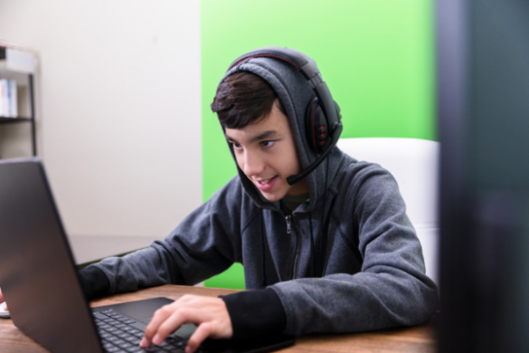 boy wearing headset on computer